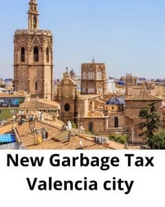 Valencia city rooftops and historic towers under a clear blue sky, with bold white text saying 'New Garbage Tax Valencia city' across the bottom.